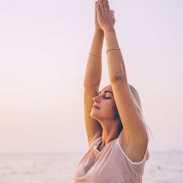 Person stretching outdoors during a sunrise, feeling energized.